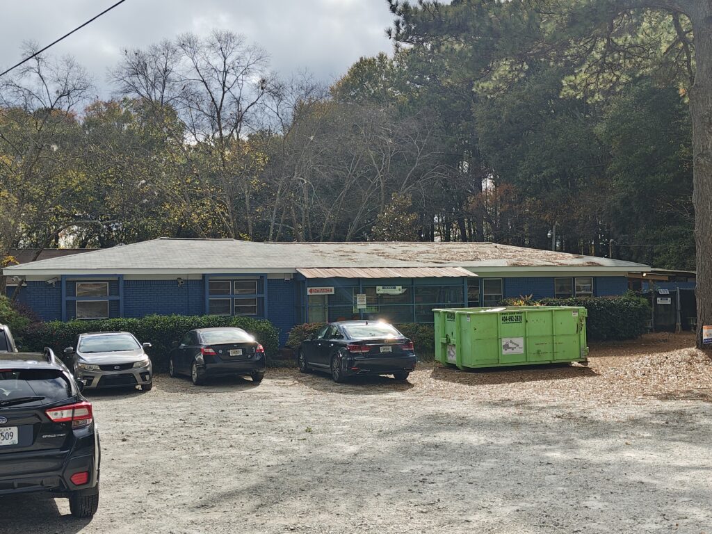 The PAWS Atlanta Cat Cottage with a green Bin There Dump That dumpster on site during the renovation.