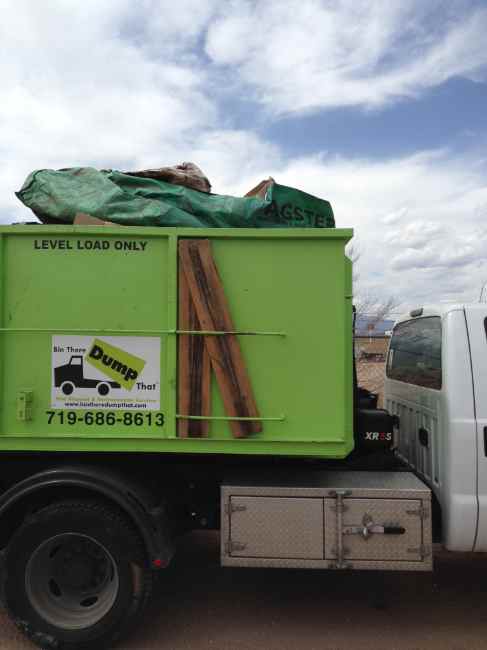 Dumpster loaded above the rail beside a LEVEL LOAD ONLY marking