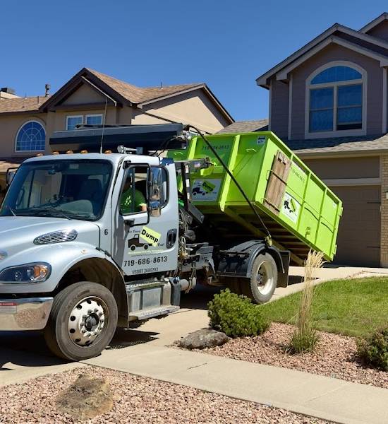 Bin There Dump That truck placing a dumpster on a Colorado Springs driveway