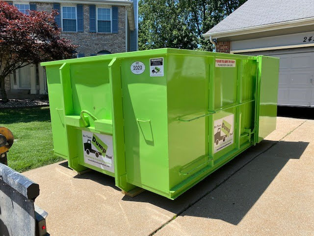 shiny, clean, green dumpster in driveway