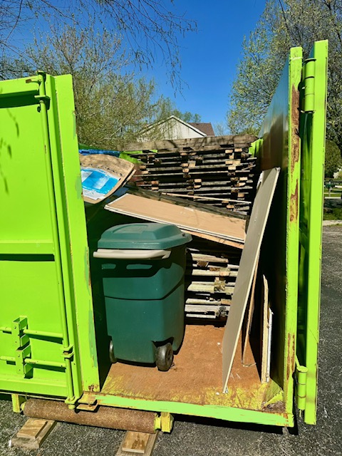 Green Bin There Dump That dumpster rental loaded with old fencing and construction debris in Plainfield, IL.