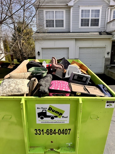 Bin There Dump That dumpster rental filled with furniture and household junk during a home cleanout in Plainfield, IL.