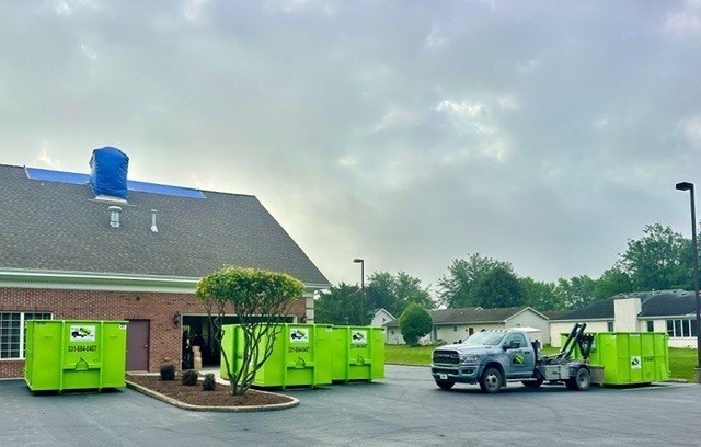 Green construction dumpsters and a Bin There Dump That delivery truck for dumpster rental in Plainfield, IL.