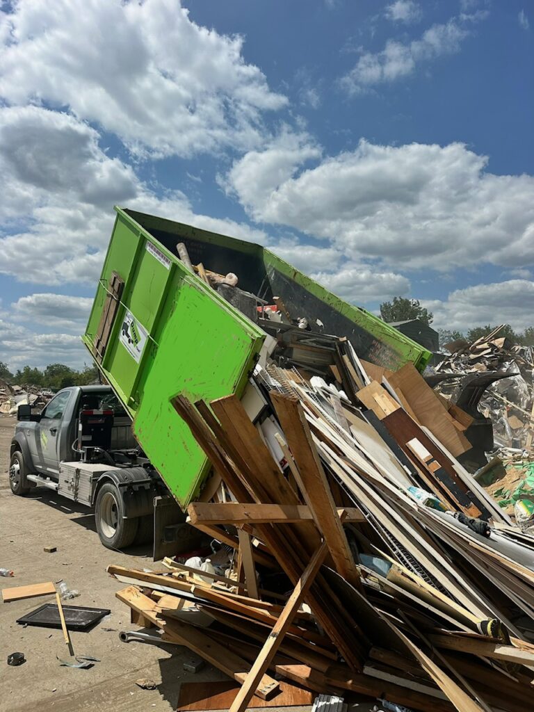 Green Bin There Dump That dumpster unloading wood and construction debris from a dumpster rental in Plainfield, IL.