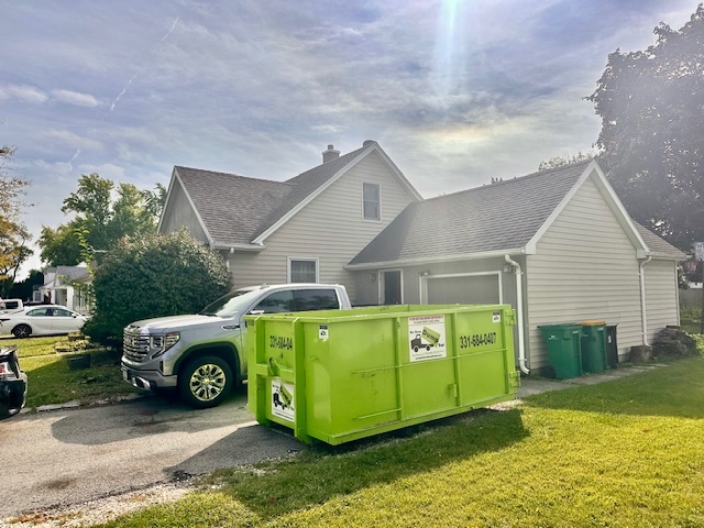 Green Bin There Dump That residential dumpster rental and delivery truck outside a home in Plainfield, IL.
