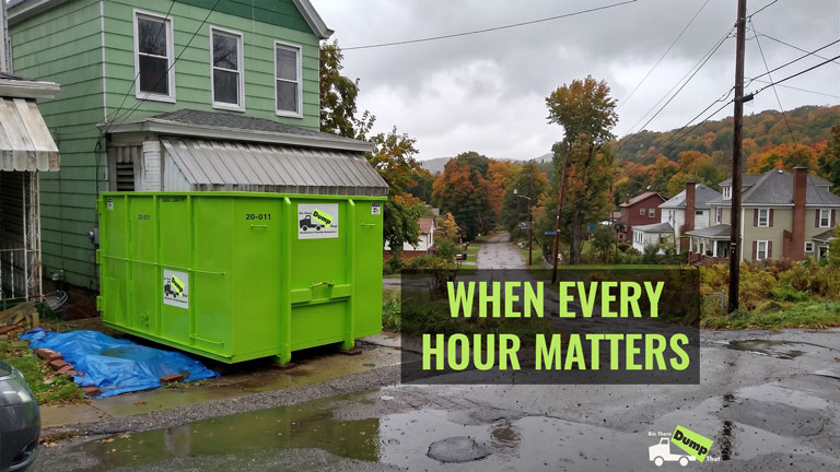 Disaster restoration crew working beside a green residential dumpster in Upstate New York