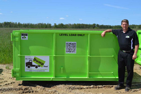 A man stands next to a Bin There Dump That dumpster bin